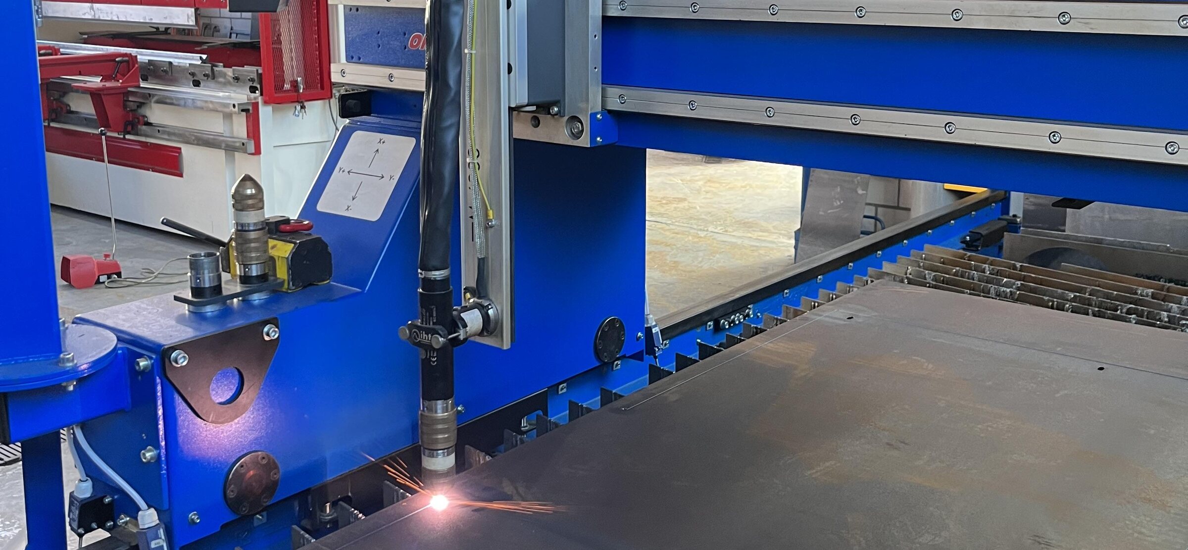 Brenner der CNC-Brennschneidanlage schneidet eine Stahlplatte, Funken am Schnitt