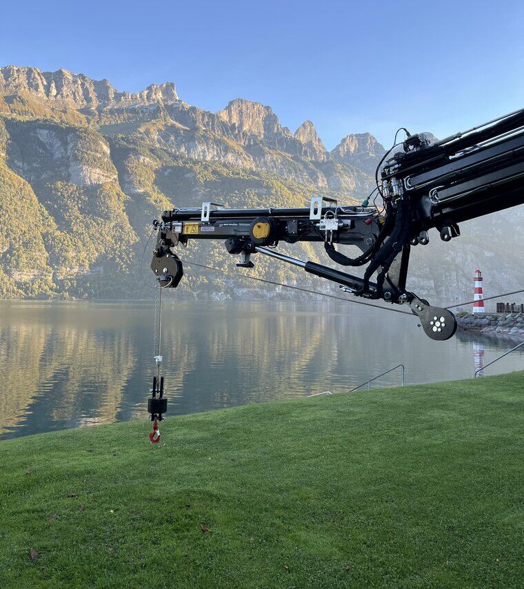 Aufgebauter Ladekran mit ausgefahrenem Ausleger über dem Walensee